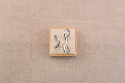 Zilverkleurige open ring met organisch vloeiend gevormde band, op witte achtergrond