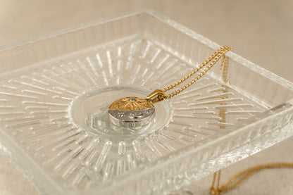 Detail van de celestial hanger met maan, zon en ster aan een fijne goudkleurige schakelketting