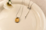 Zilverkleurige ketting met dubbele organische cirkelhanger aan een fijne schakelketting