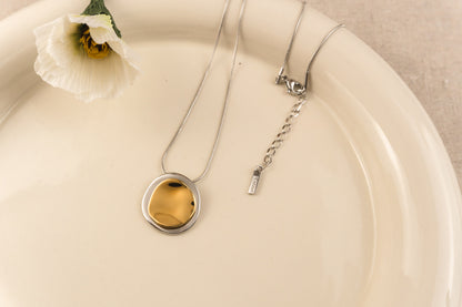 Zilverkleurige ketting met dubbele organische cirkelhanger aan een fijne schakelketting