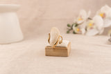 Goudkleurige ring met ronde crèmekleurige harsknop, op witte achtergrond