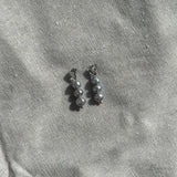 Detail van grijze zoetwaterparel oorbel van roestvrij staal