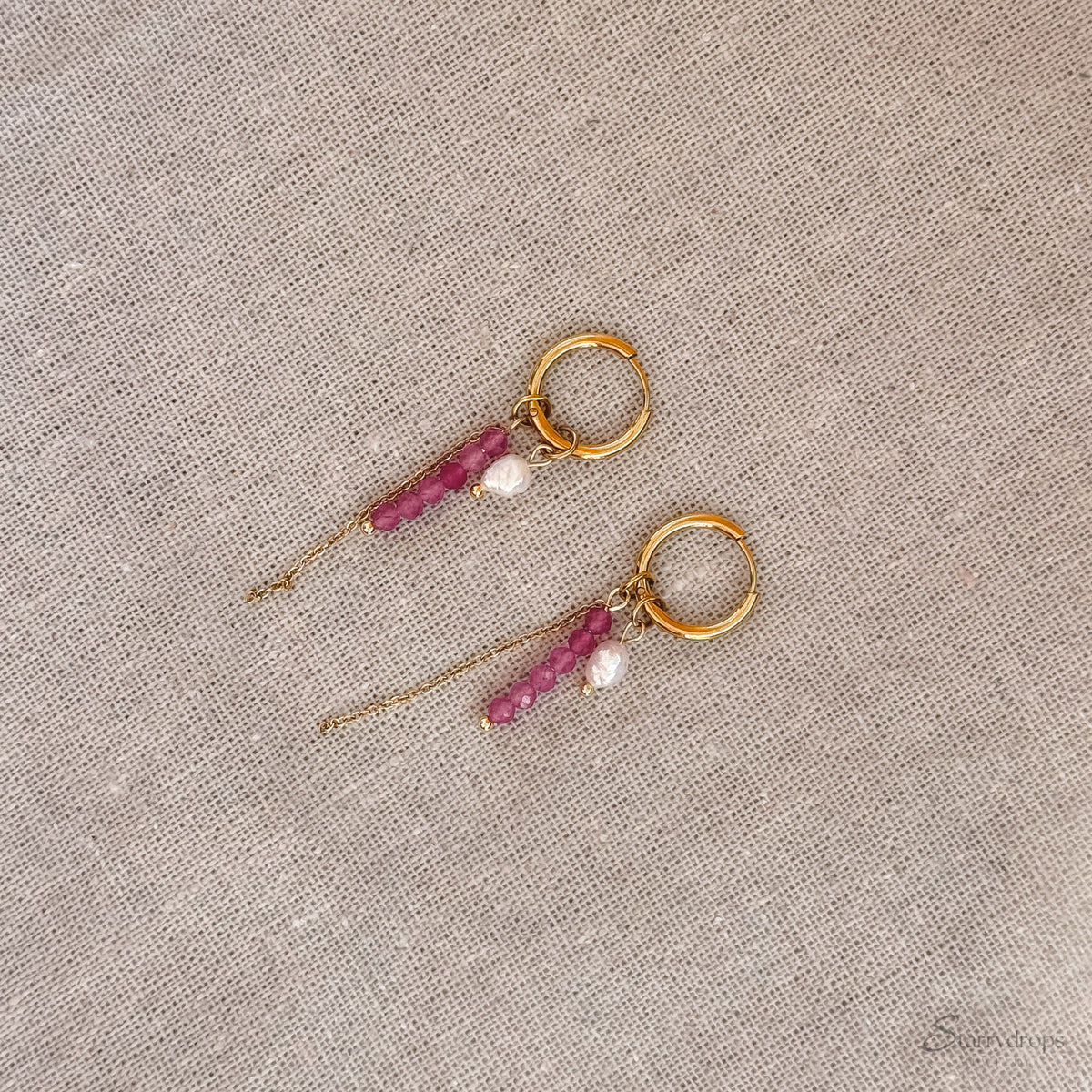 Detail van fuchsia hoop oorbel met roze toermalijn