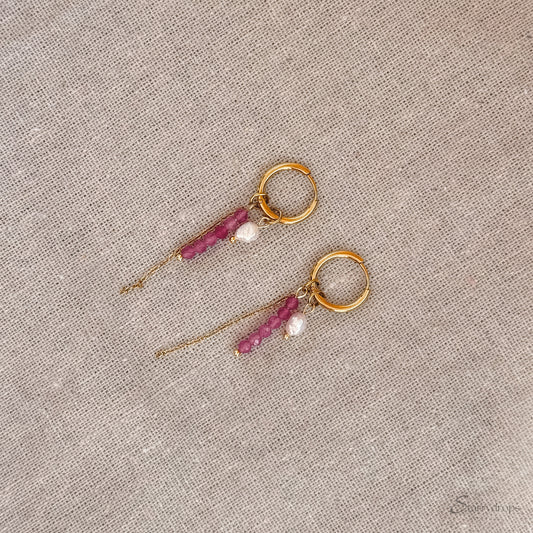 Detail van fuchsia hoop oorbel met roze toermalijn