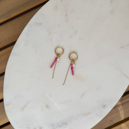 Detail van fuchsia hoop oorbel met roze toermalijn