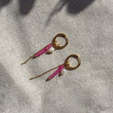 Detail van fuchsia hoop oorbel met roze toermalijn