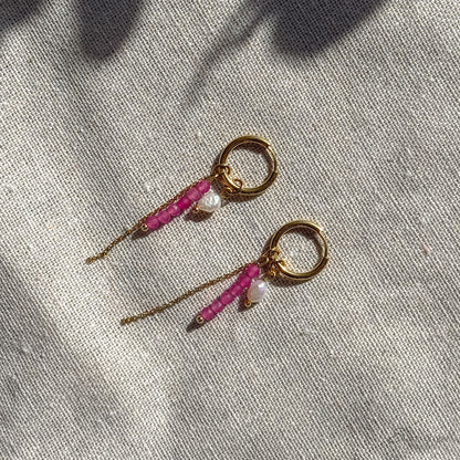 Detail van fuchsia hoop oorbel met roze toermalijn