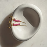 Detail van fuchsia hoop oorbel met roze toermalijn