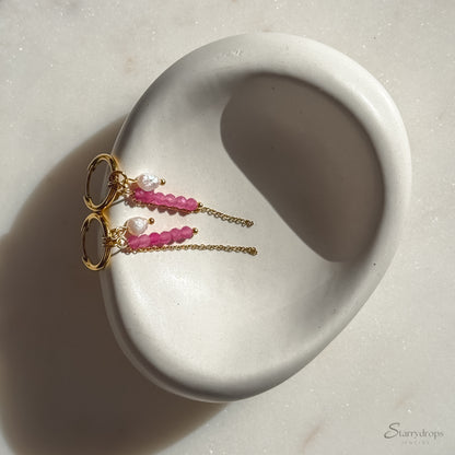 Detail van fuchsia hoop oorbel met roze toermalijn