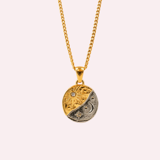 Goudkleurige ketting met celestial hanger die half goud- en half zilverkleurig is, met maan, zon en ster