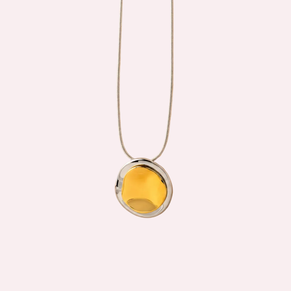 Zilverkleurige ketting met hanger van twee organische cirkels, goudkleurig bovenop zilverkleurig
