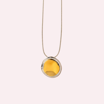 Zilverkleurige ketting met hanger van twee organische cirkels, goudkleurig bovenop zilverkleurig
